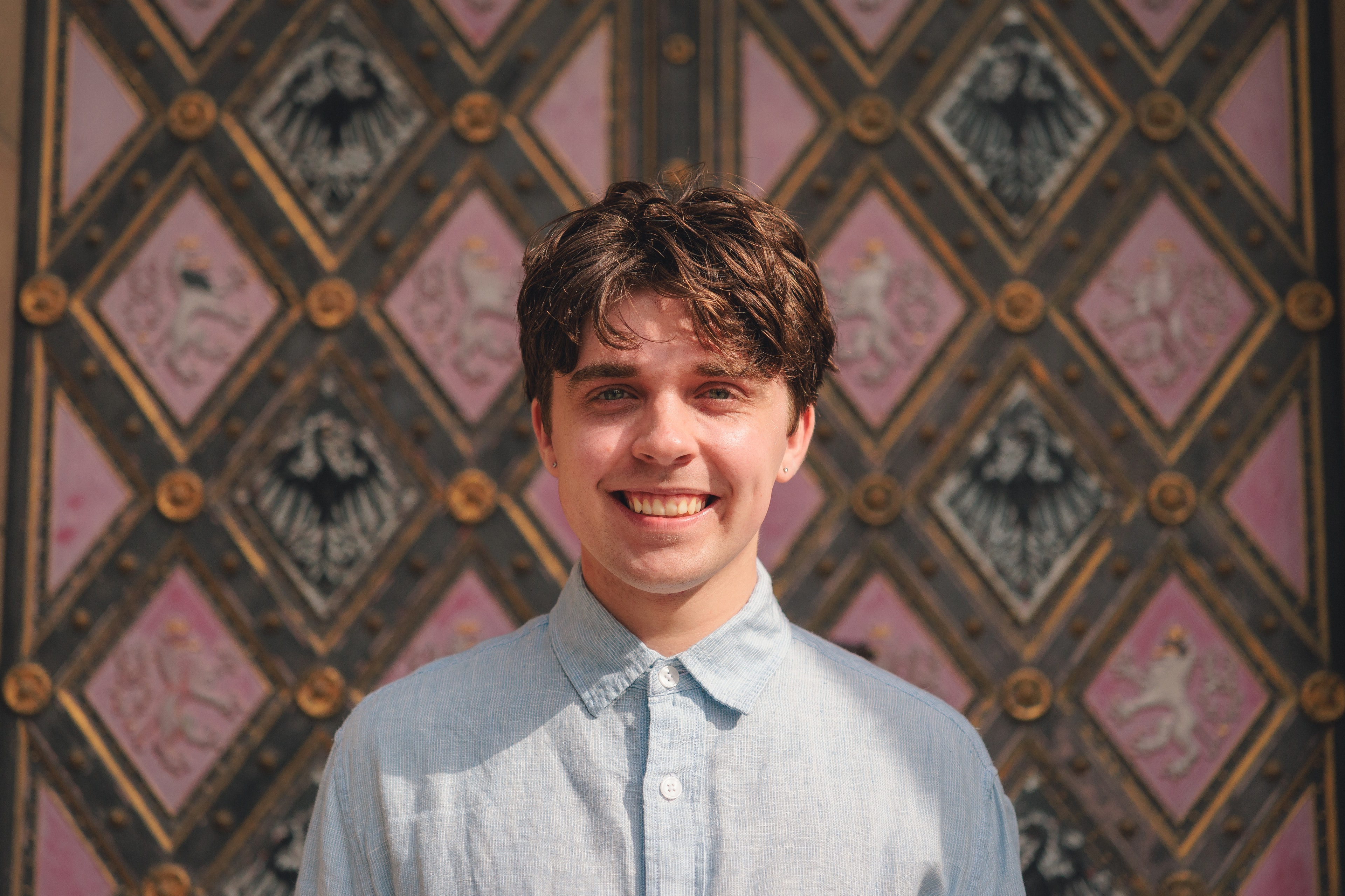 Carson Secrest smiling in front of a patterned doorway
